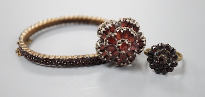 A Victorian garnet cluster set gilt metal dress ring, one other garnet set cluster ring and a garnet paste set hinged bangle.